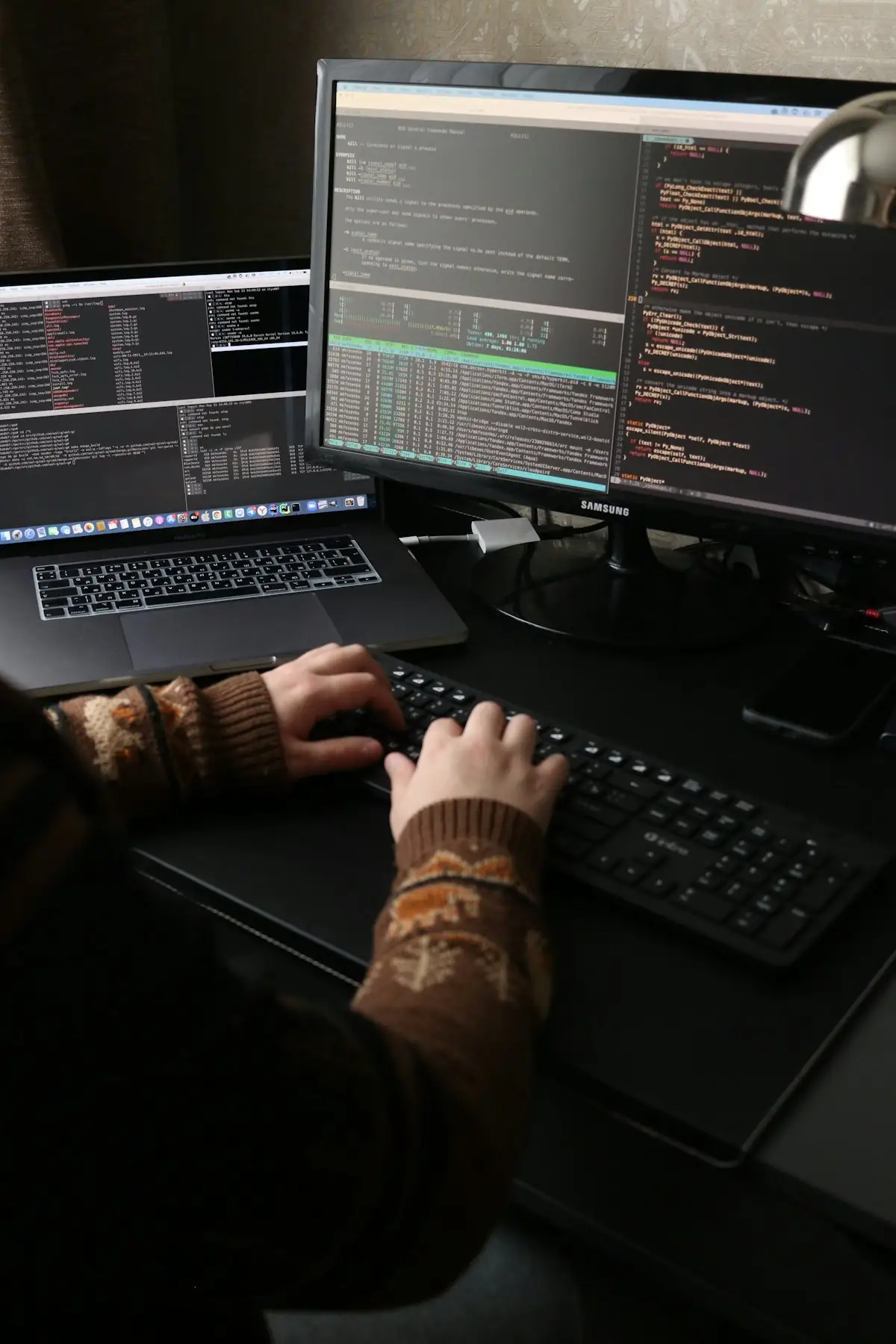 An engineer building at a multi-monitor workstation