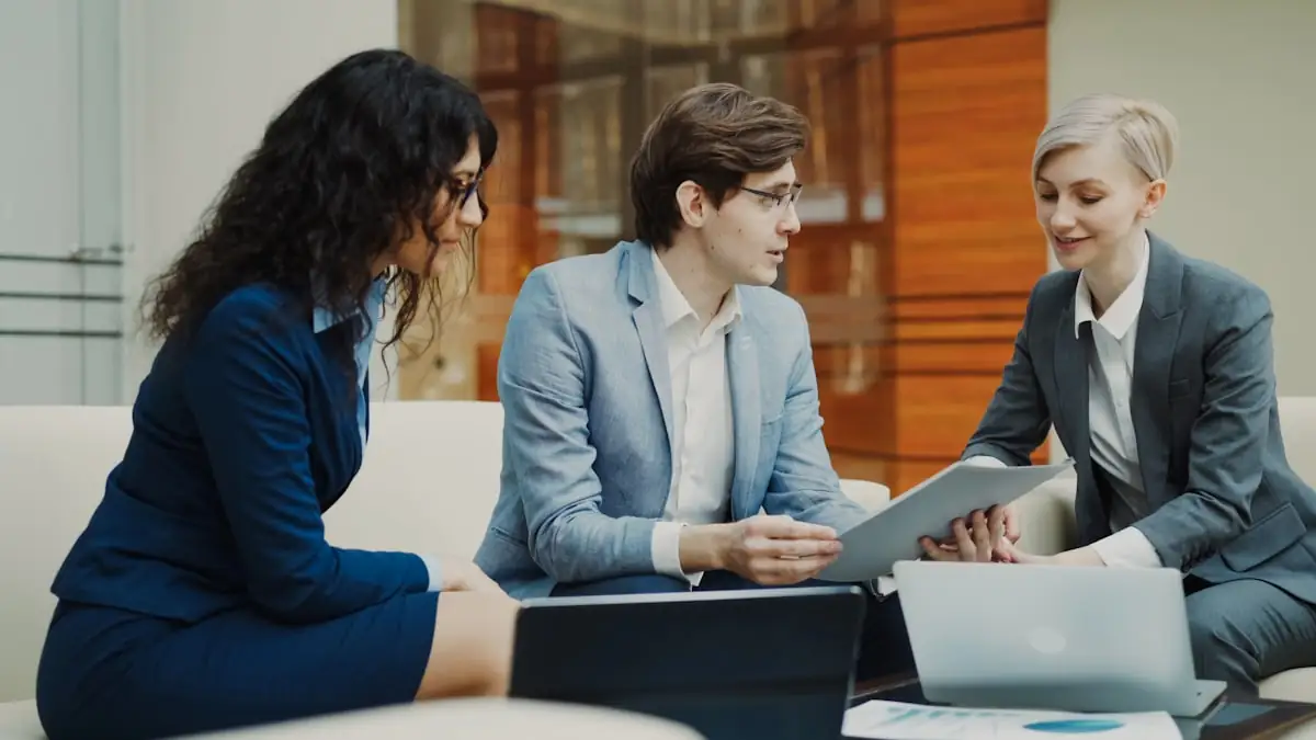Three people reviewing documents together during a discussion